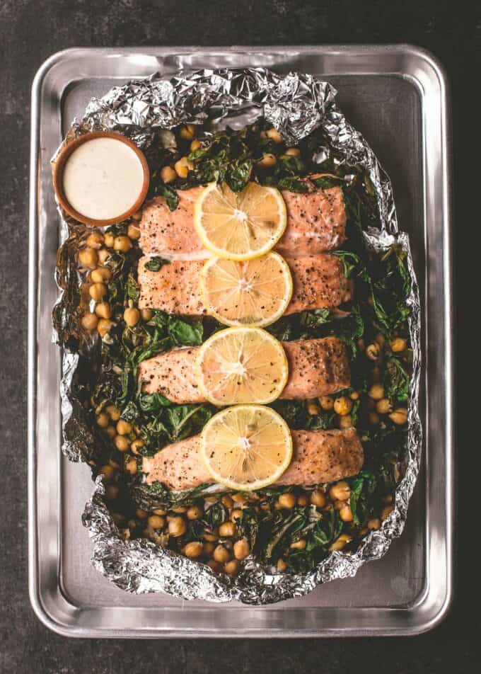 salmon and greens with sauce on a sheet pan
