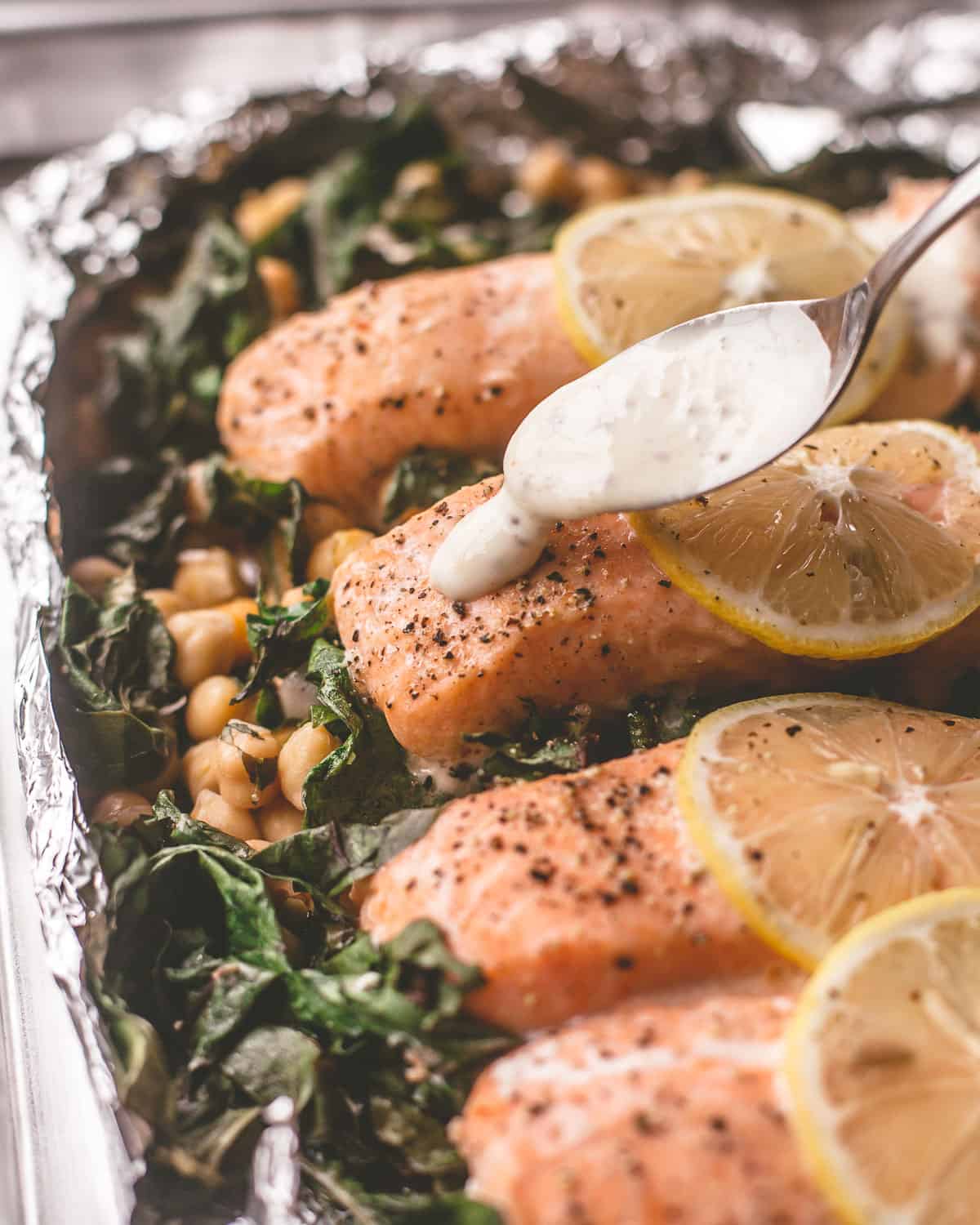 spooning sauce over foil-roasted salmon