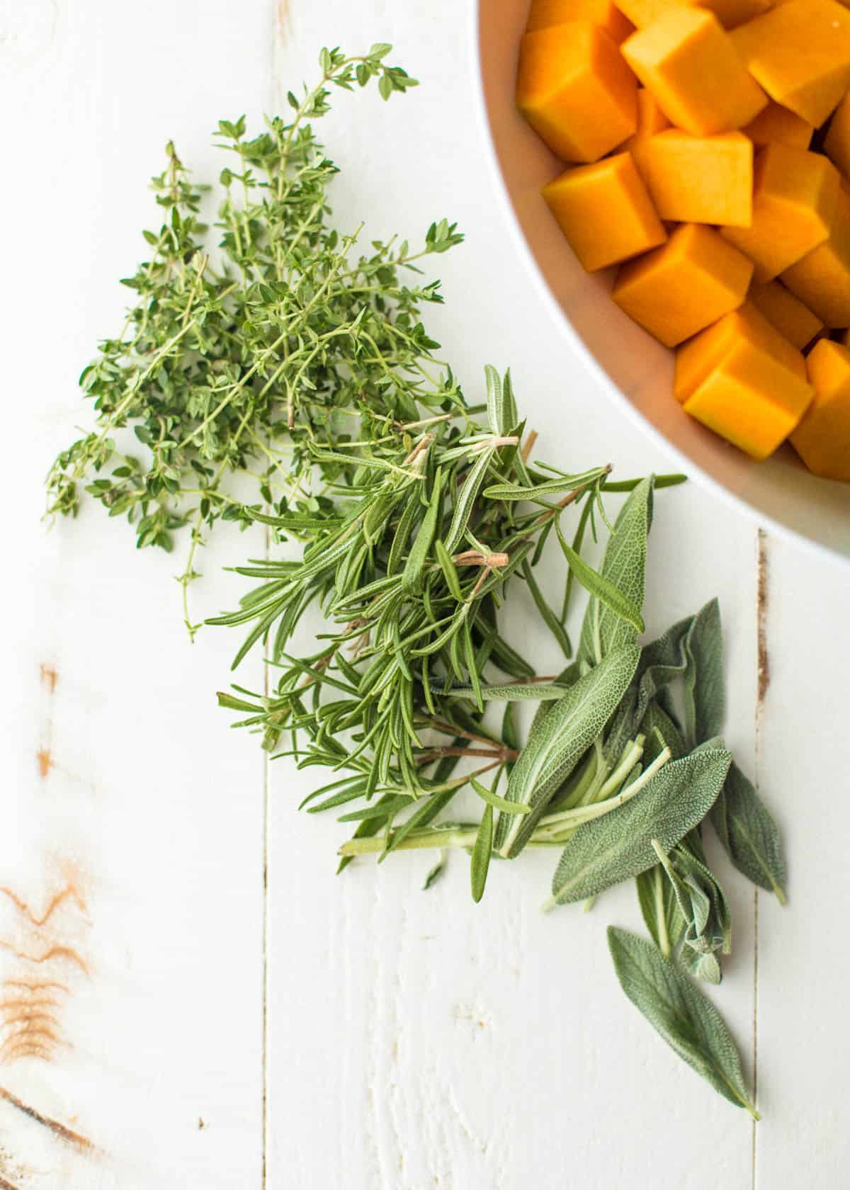 overhead image of herbs on a white table