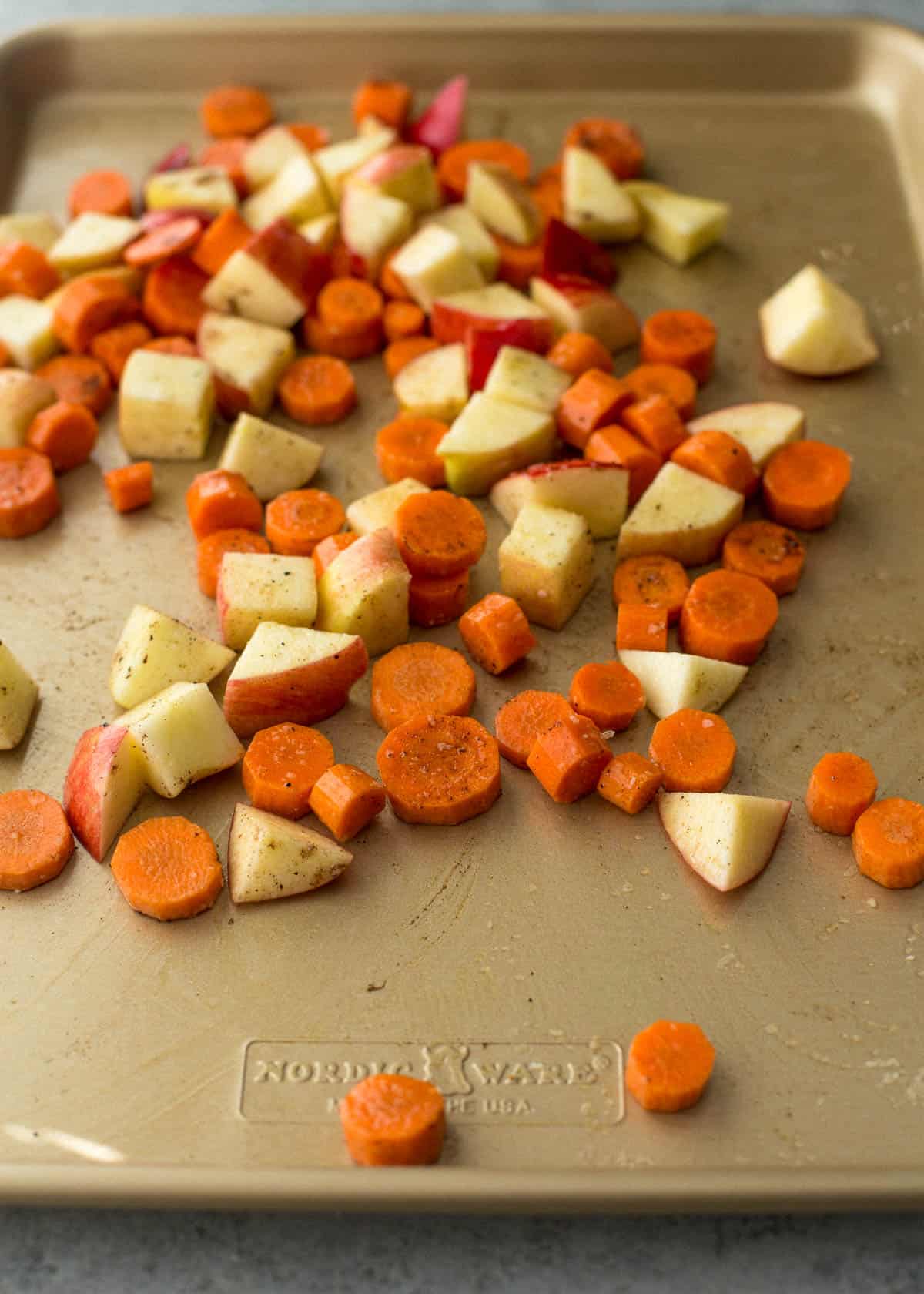 diced carrots and apples on a sheet pan