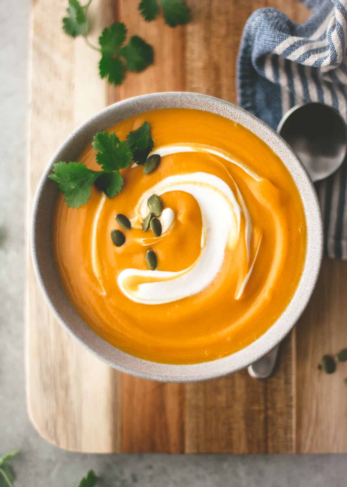 overhead image of butternut squash soup in a white bowl