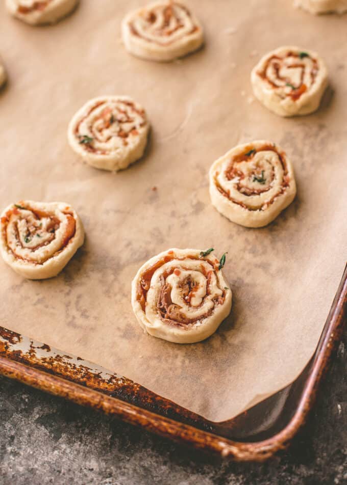 cheese pinwheels on a parchment lined sheet pan