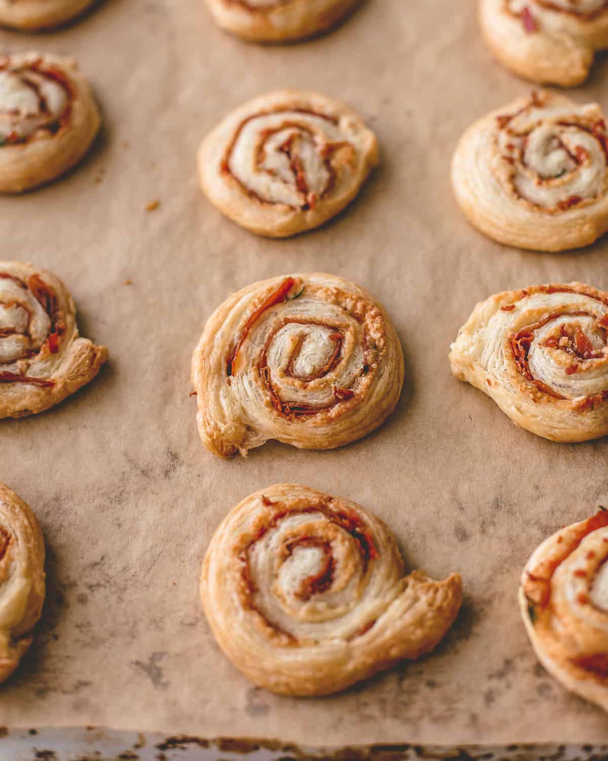 cooked cheese pinwheels on a sheet pan