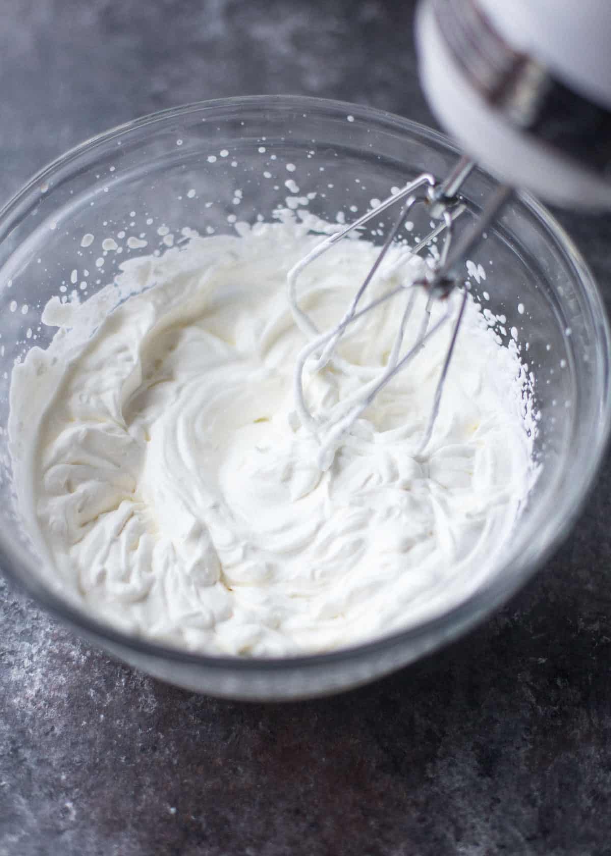 whipping cream in a clear glass bowl