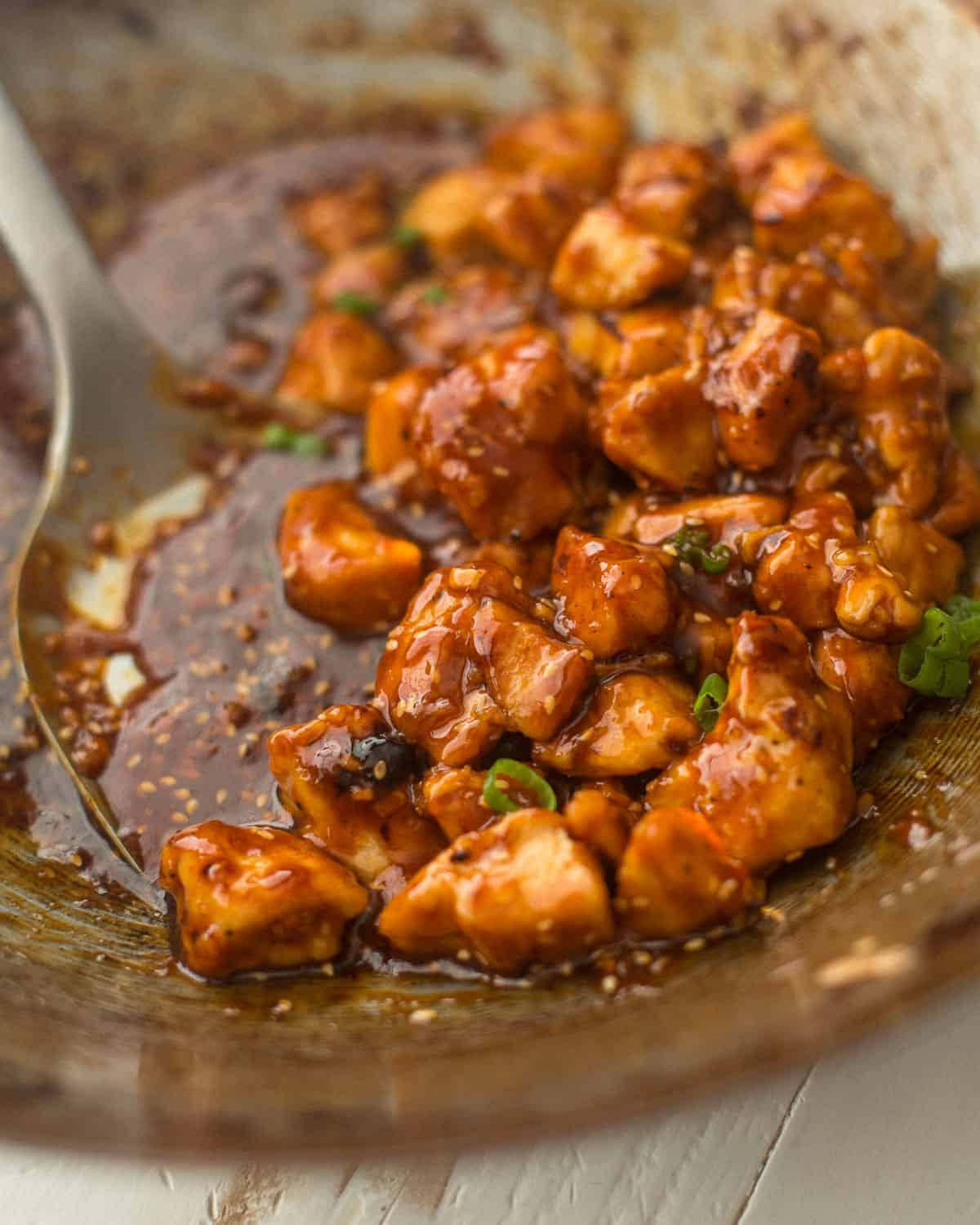 tossing sauce with chicken in a wok