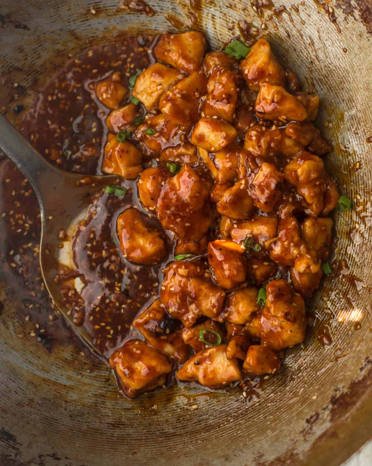 chicken tossed with sauce in a wok