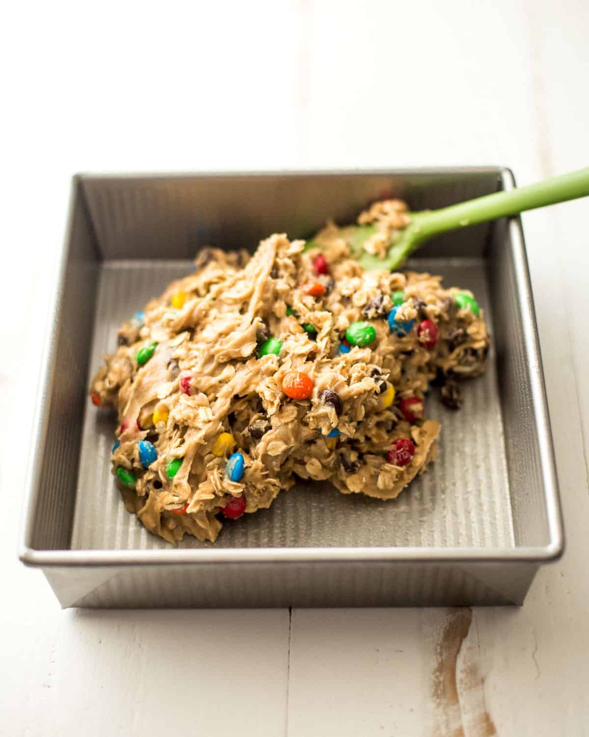 putting cookie dough mix into a baking pan