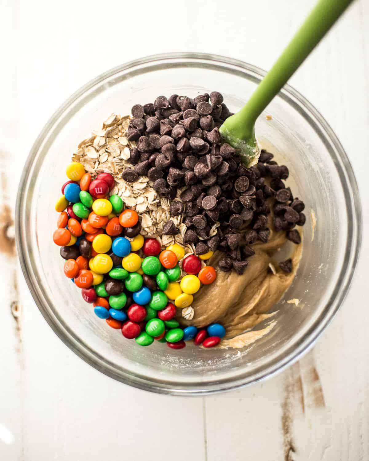 overhead image of oatmeal, chocolate chips, and candy in a glass bowl