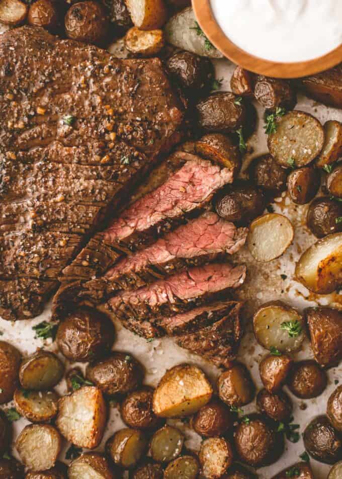 steak and potatoes on a parchment lined sheet pan