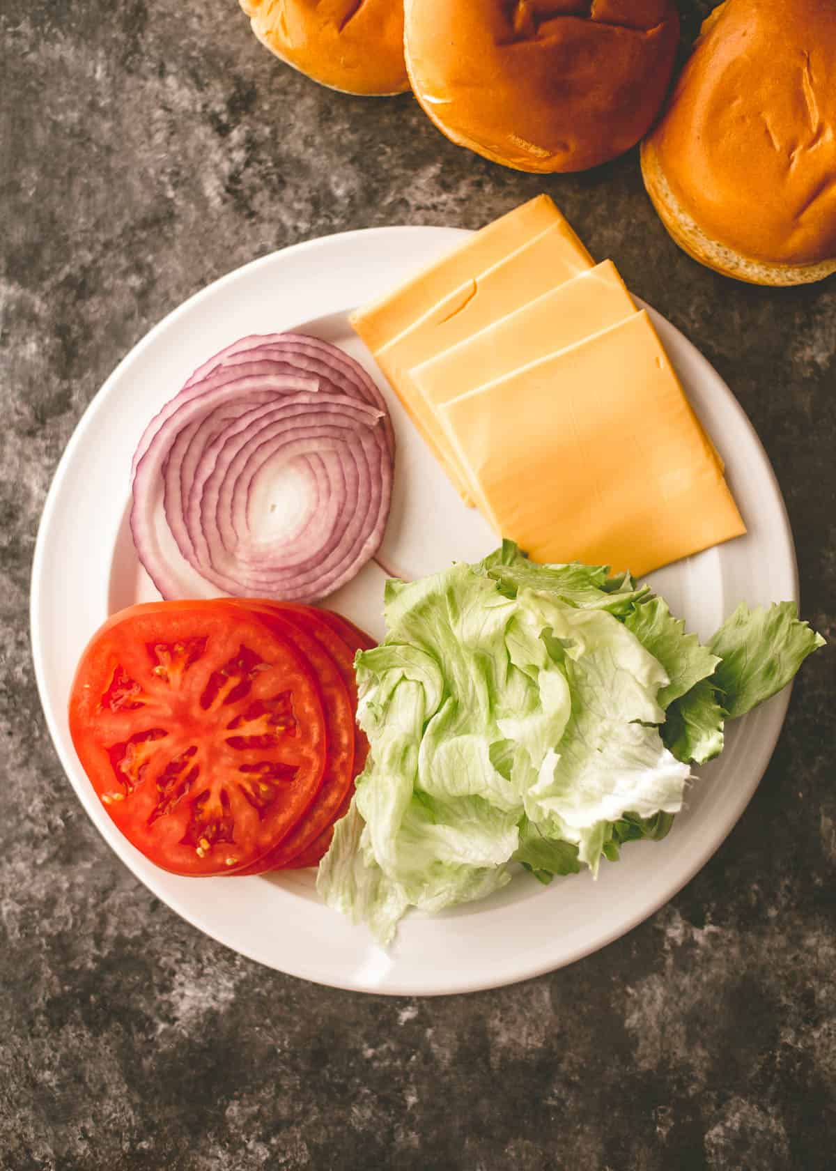 overhead image of hamburger toppings on a white plate