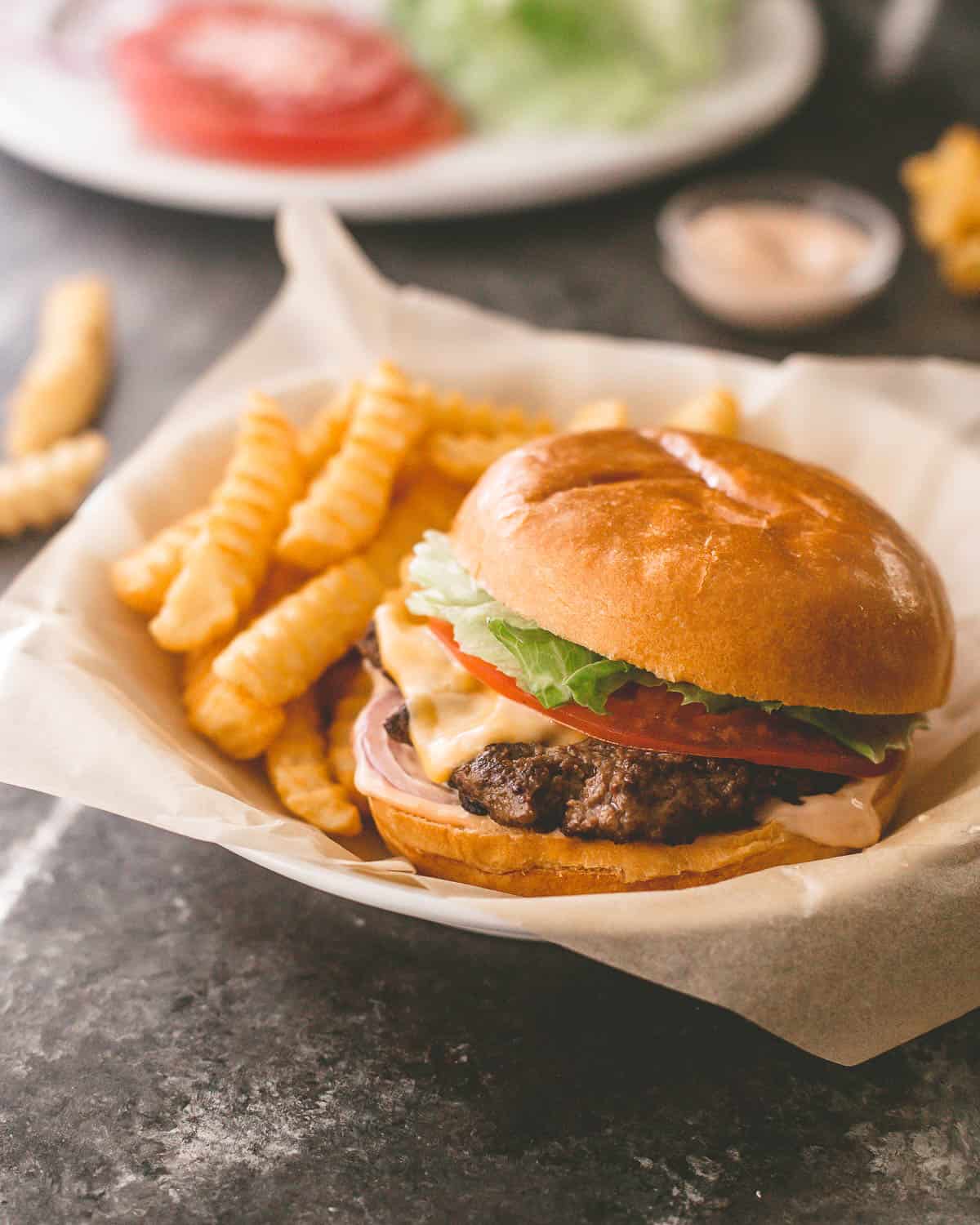 a burger and fries in a paper lined basket