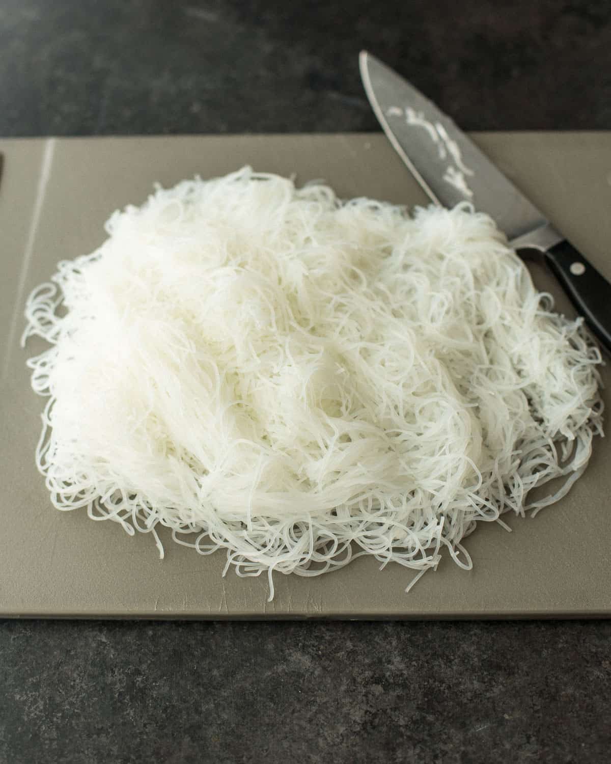 rice noodles and a knife on a cutting board