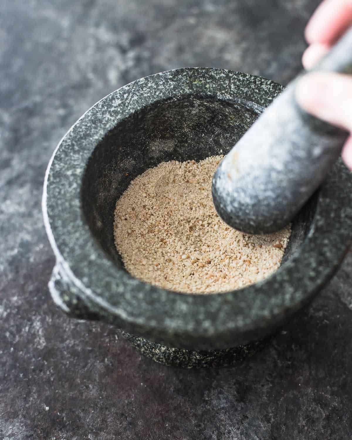 overhead image of grinding rice powder in a mortar and pestle