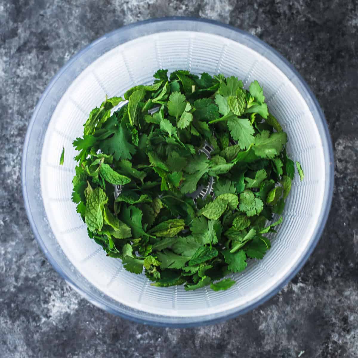 overhead image of fresh herbs in a salad spinner