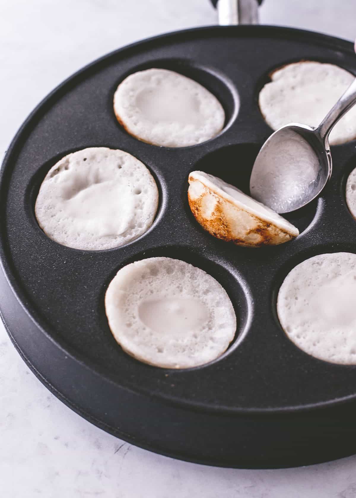 turning coconut pancakes in a pan