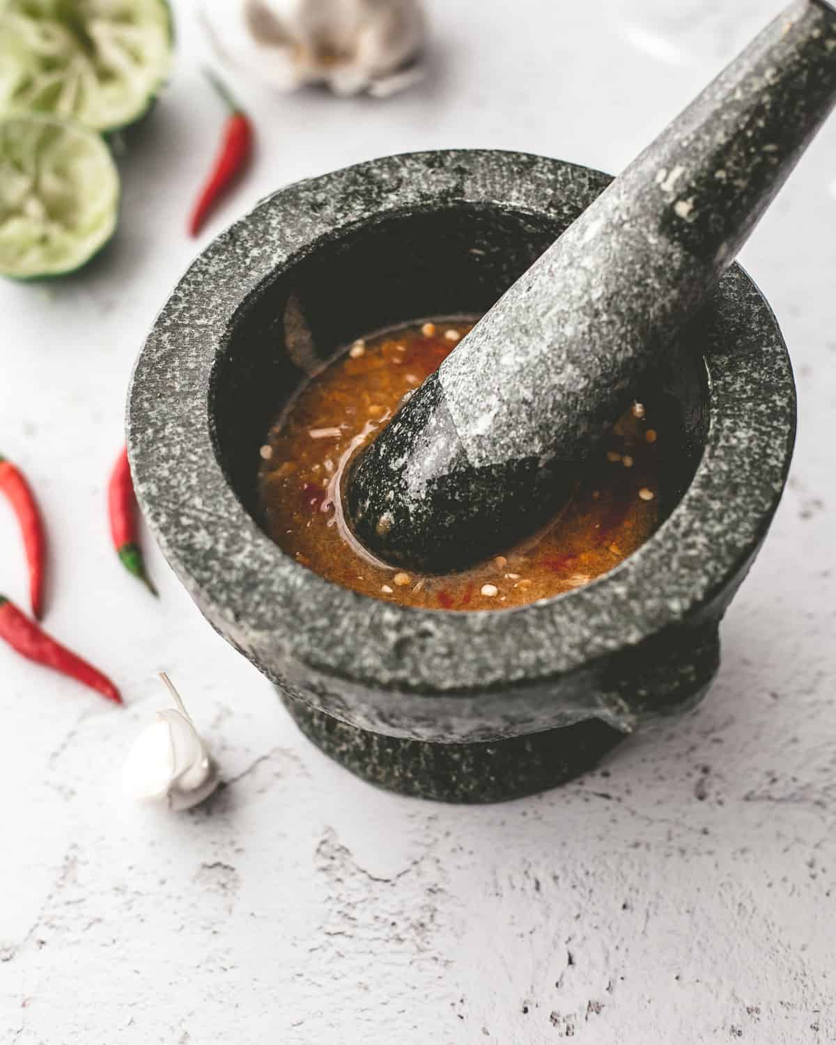 making Thai dressing with a mortar and pestle