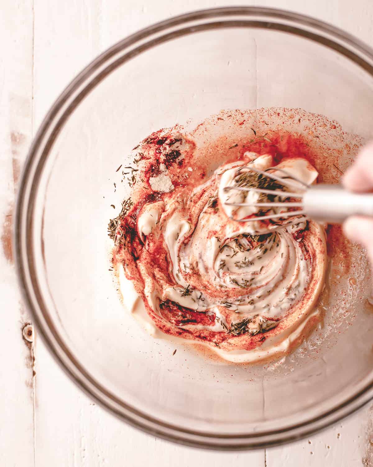 overhead image of mixing mayonnaise marinade in a clear bowl