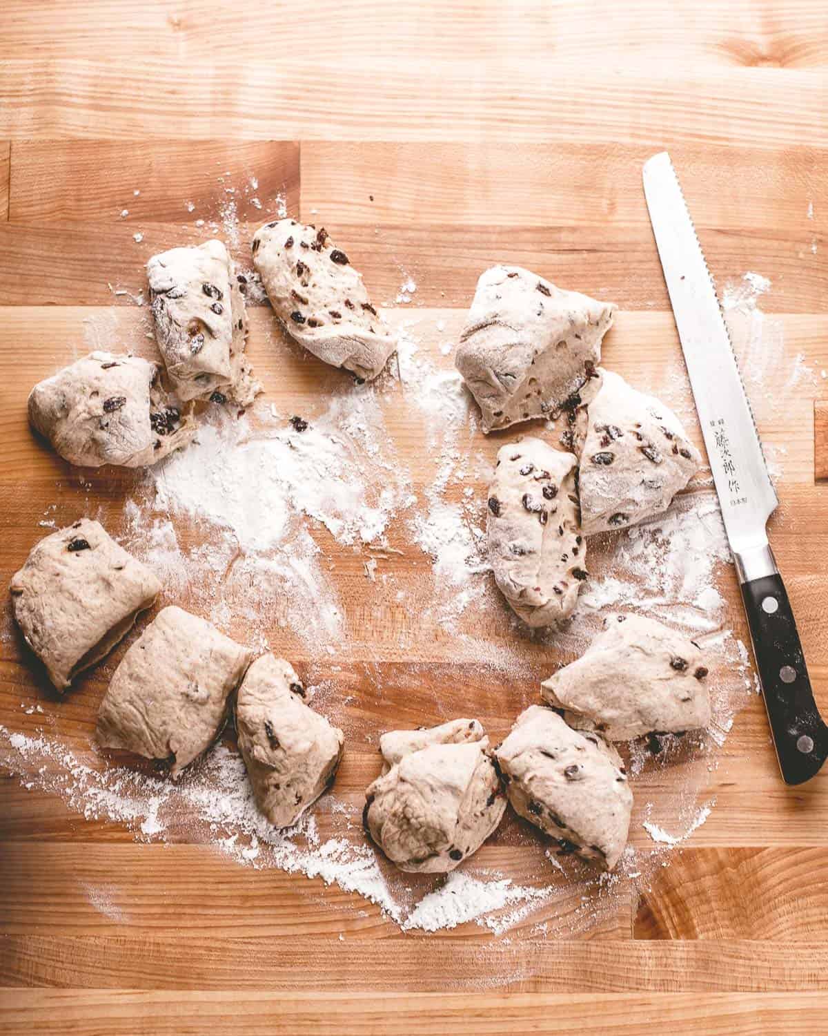 overhead image of smaller pieces of dough on a flour covered wooden table 