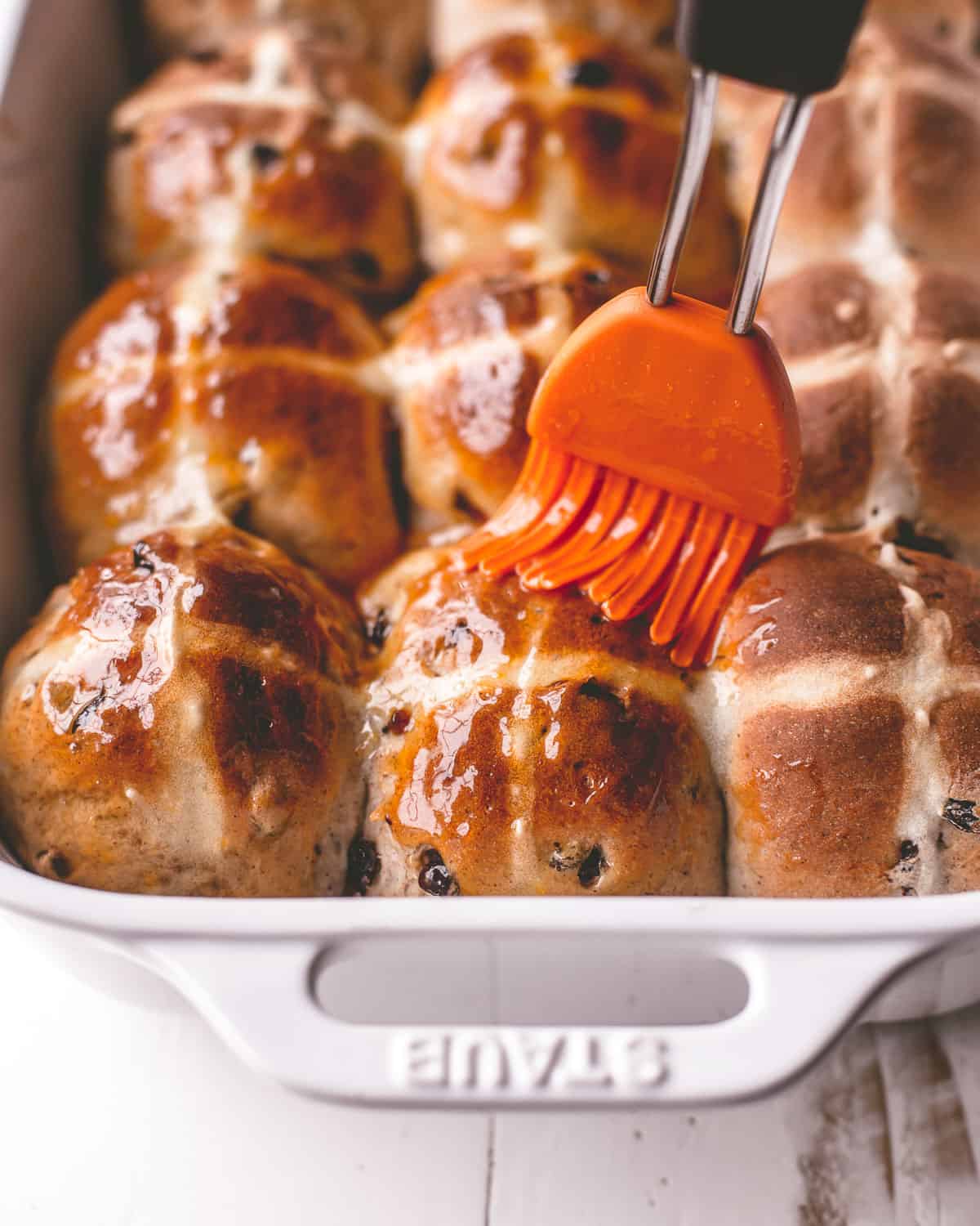 brushing baked buns with butter