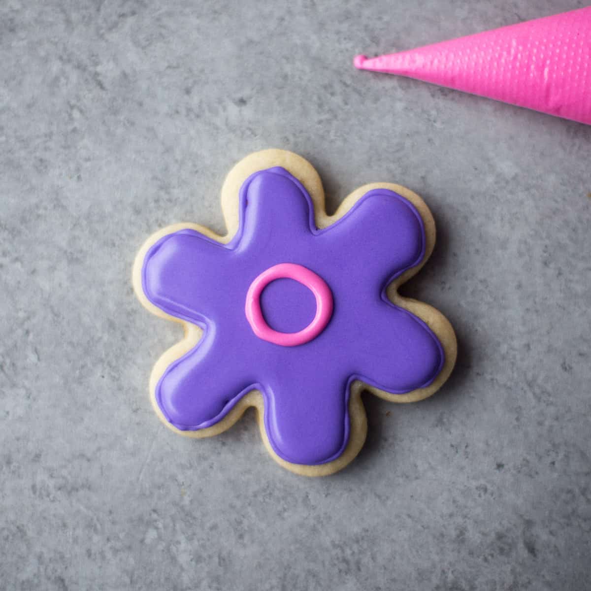 icing a flower shaped sugar cookie