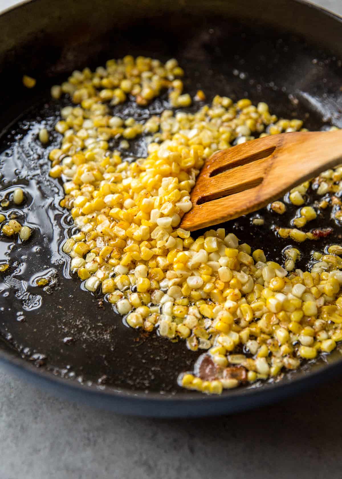 sauteeing corn kernels in a cast iron skillet