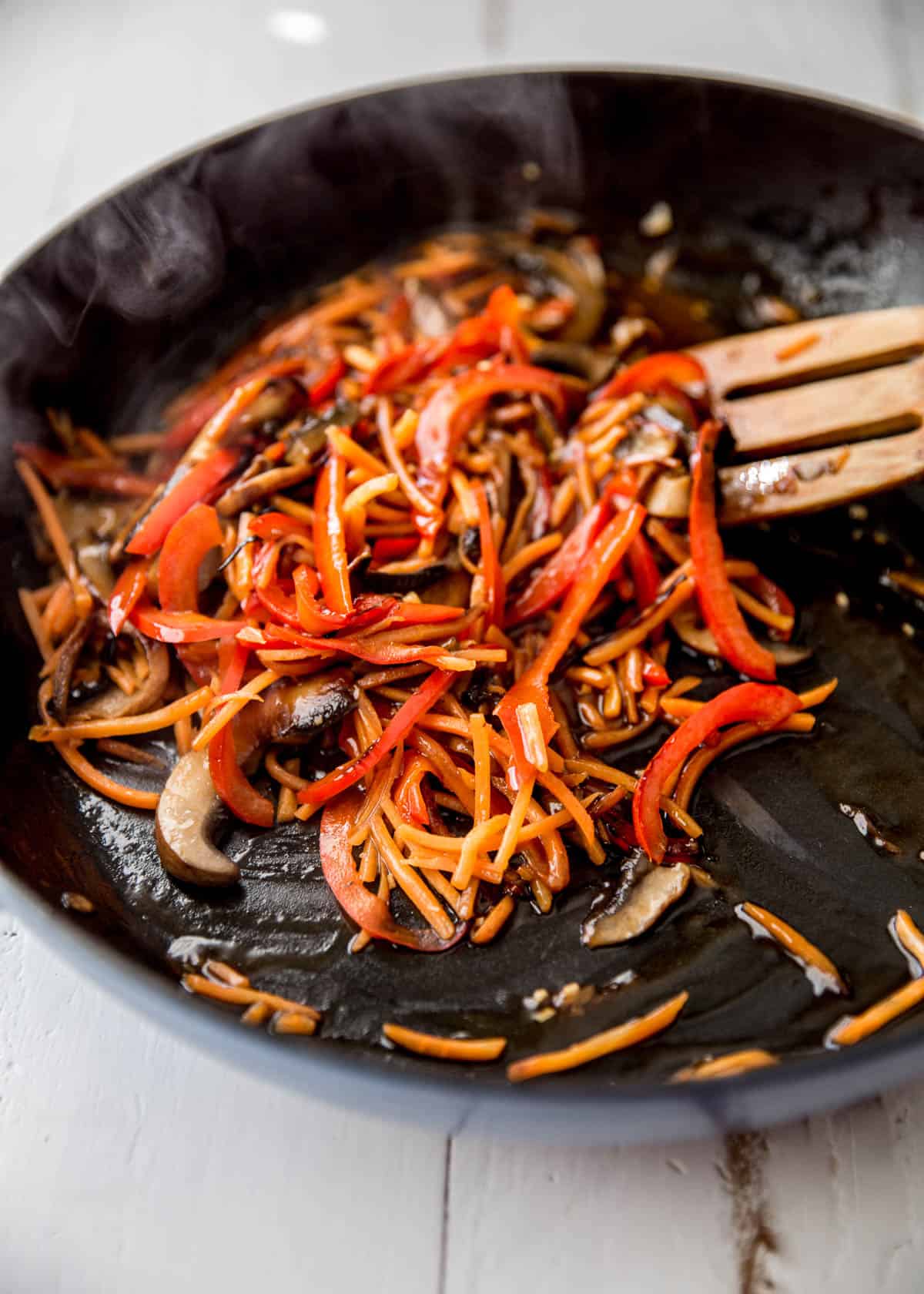 stirring vegetables in a cast iron skillet