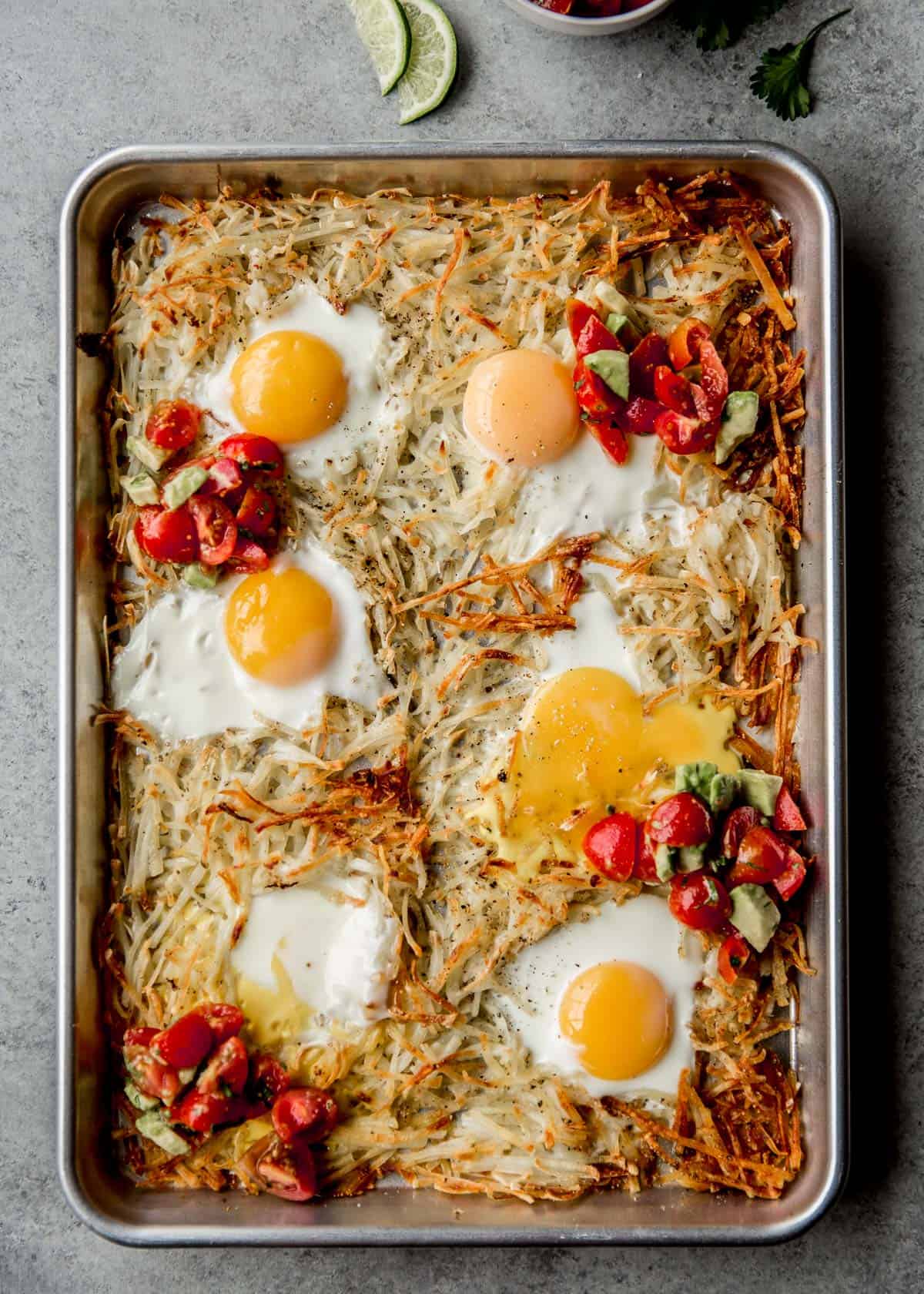 overhead image of potatoes, eggs, and salsa on a parchment lined sheet pan