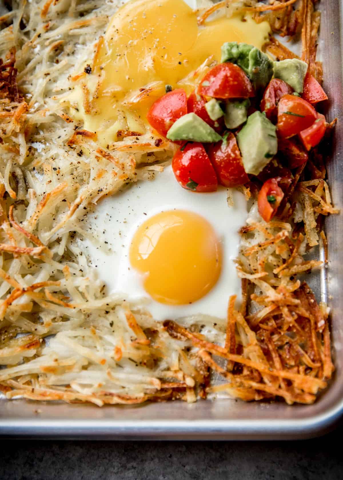 overhead image of potatoes, eggs and salsa on a sheet pan