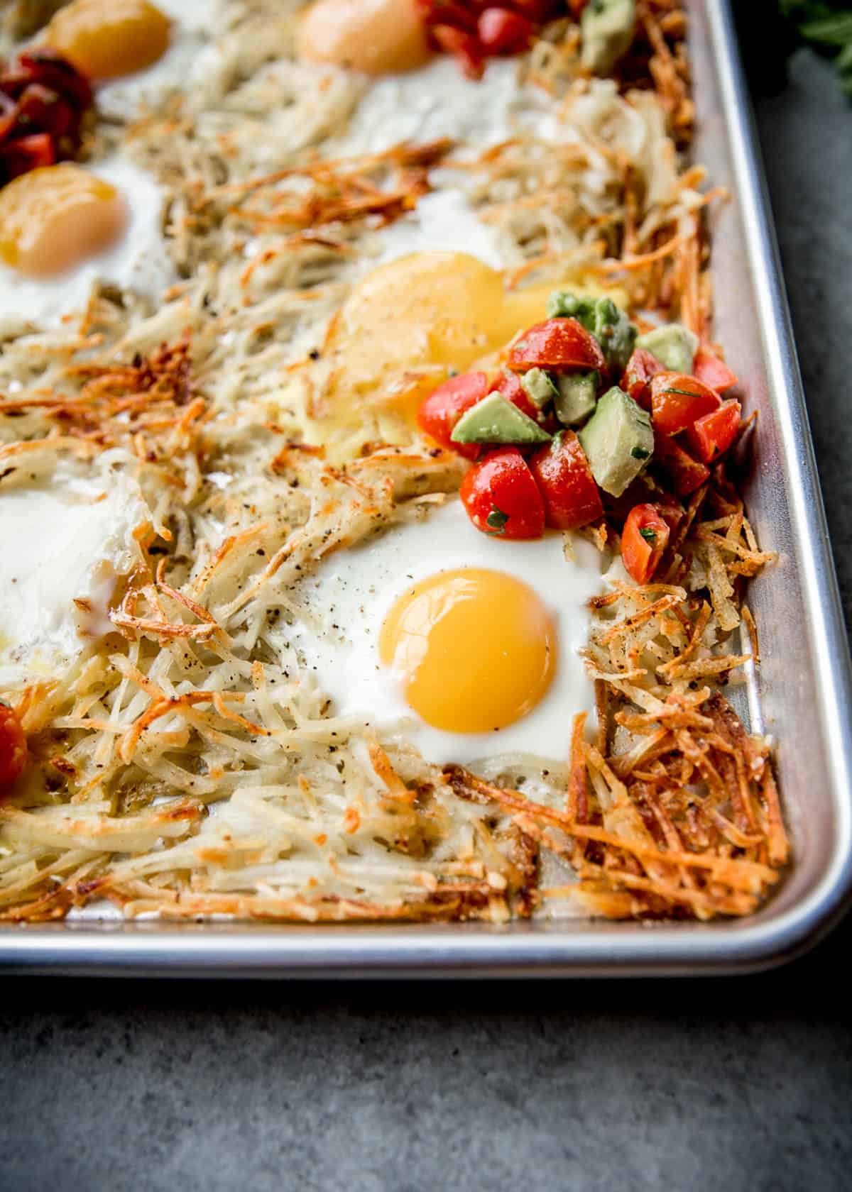 hash browns and a fried egg on a sheet pan