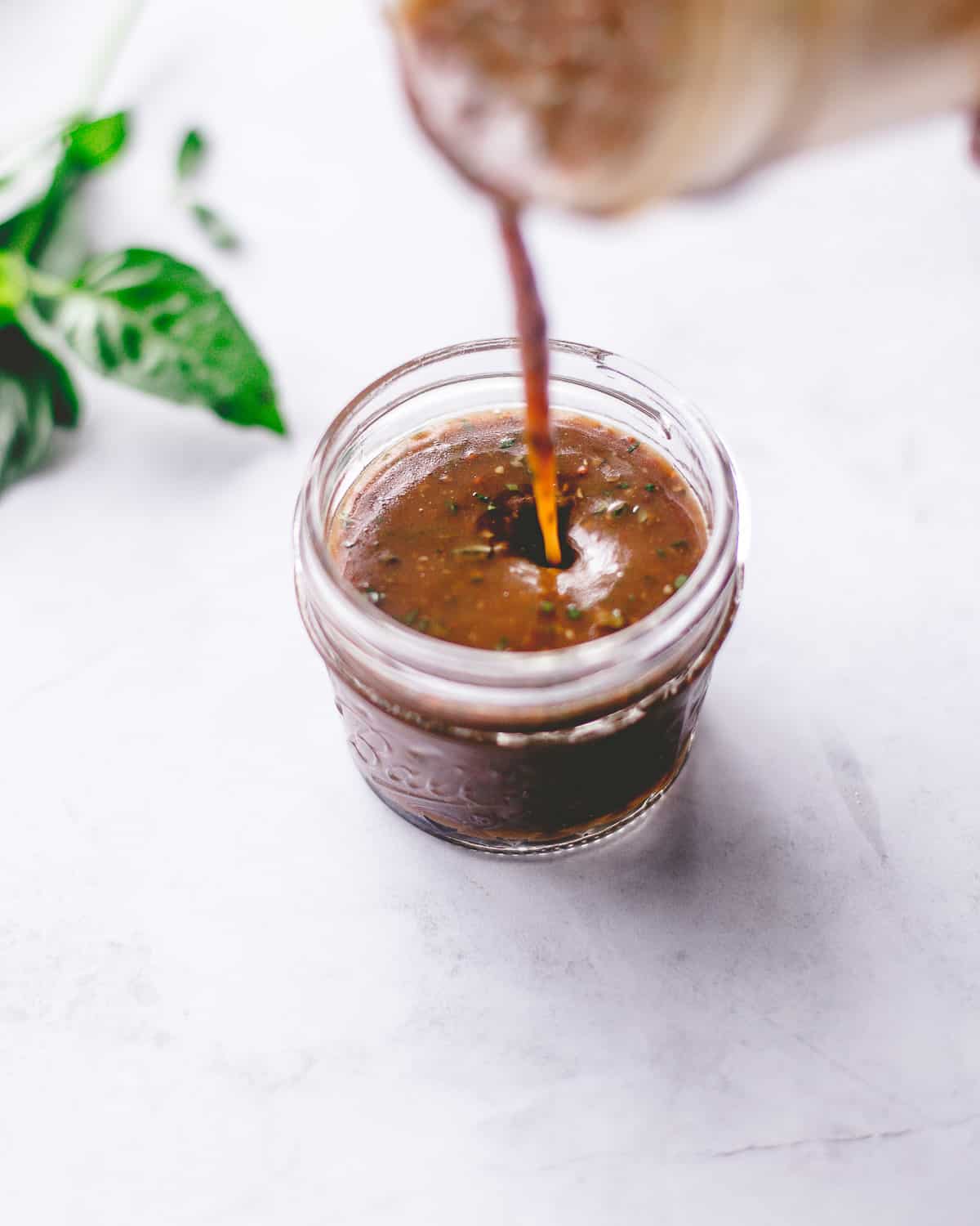 pouring dressing into a small glass jar