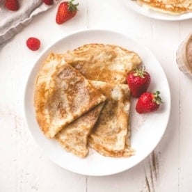 crepe and berries on a white plate