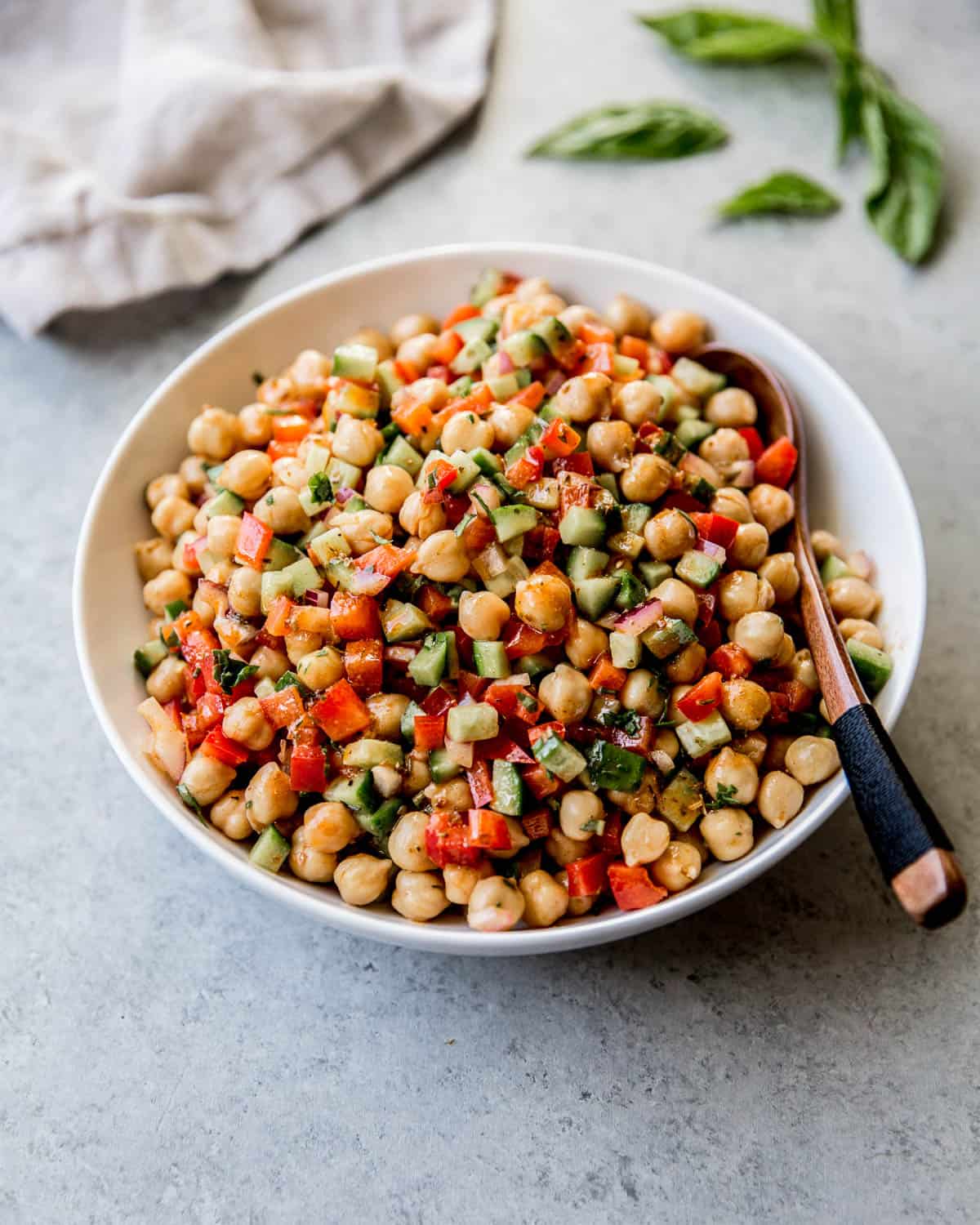 chickpeas and vegetables in a white bowl with a spoon