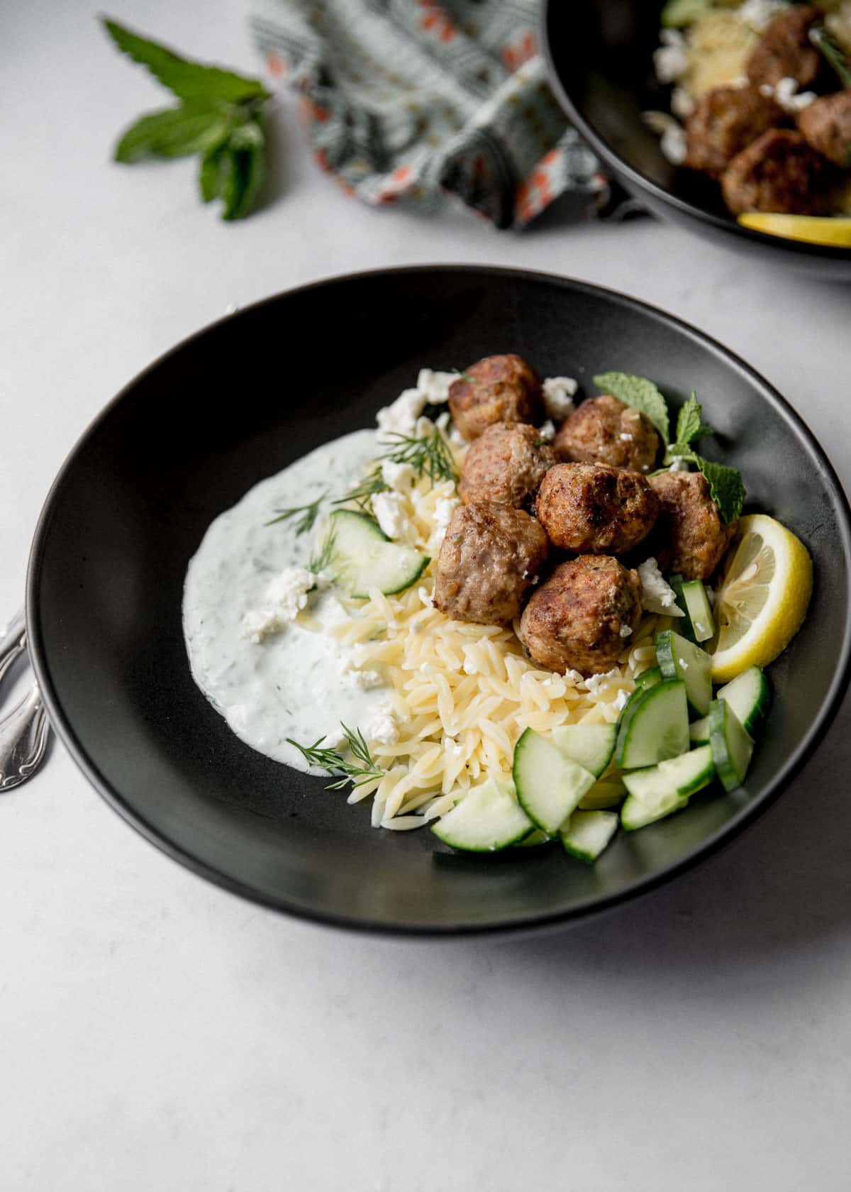 meatballs and orzo in a black bowl