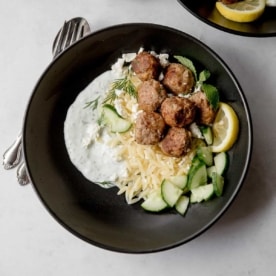 meatballs and orzo in a black bowl