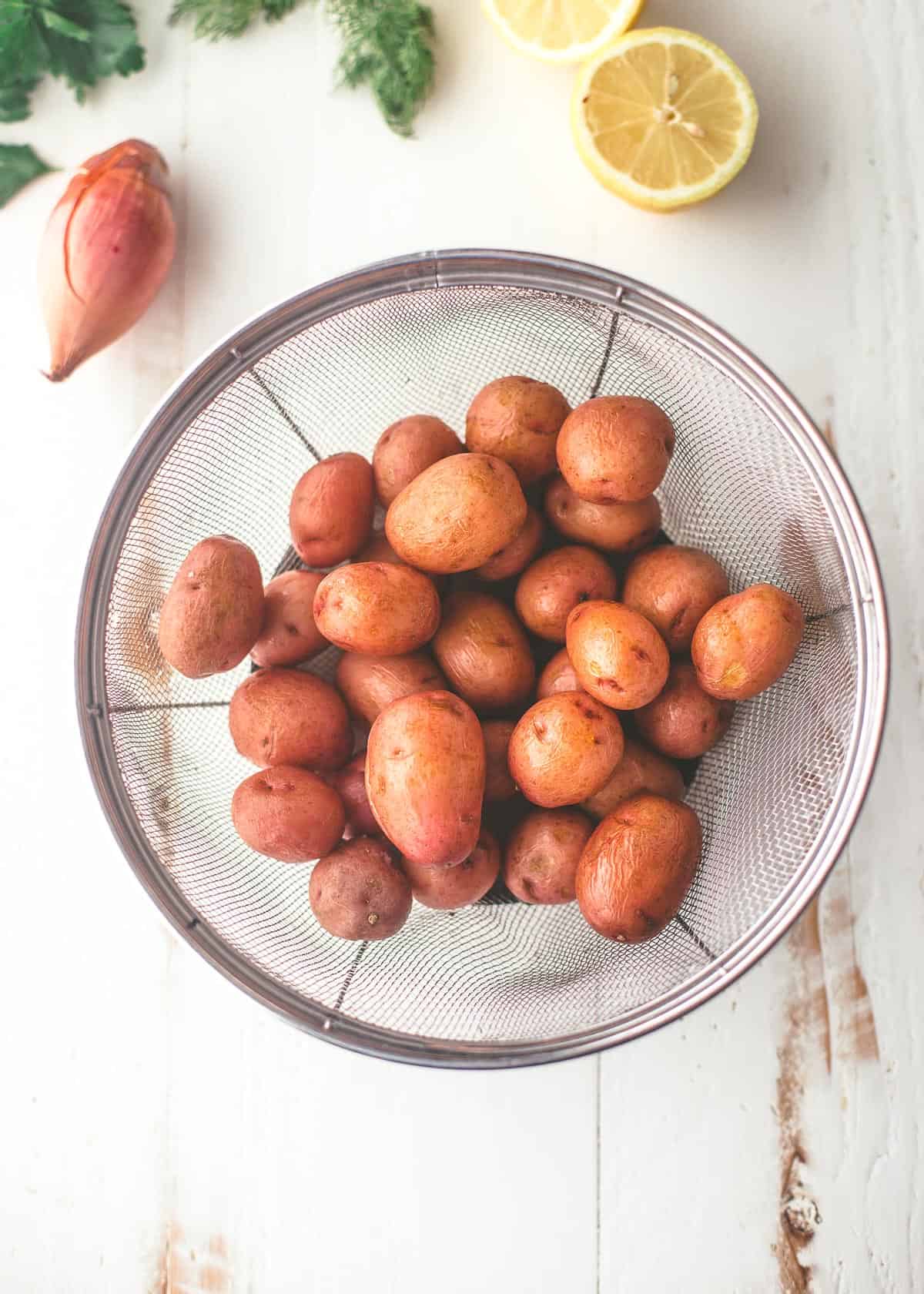 potatoes in a colander on a white table