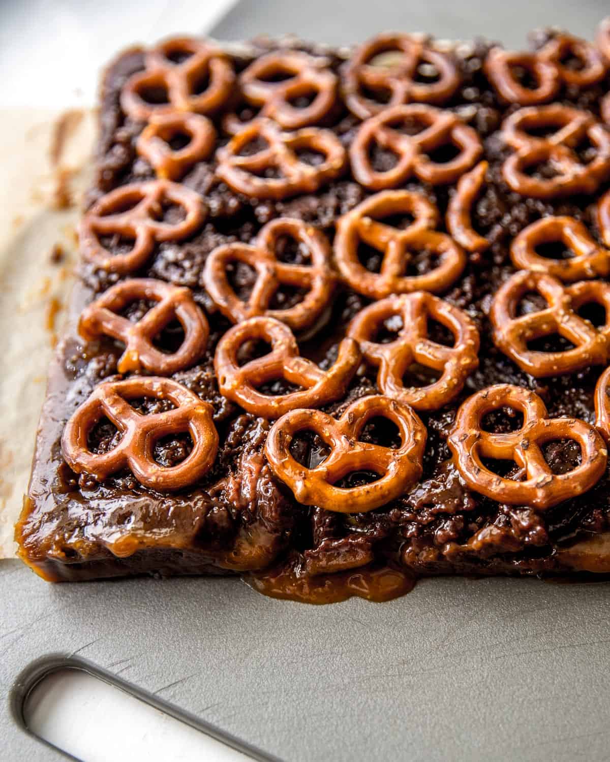pretzel topped brownies on a parchment lined sheet pan