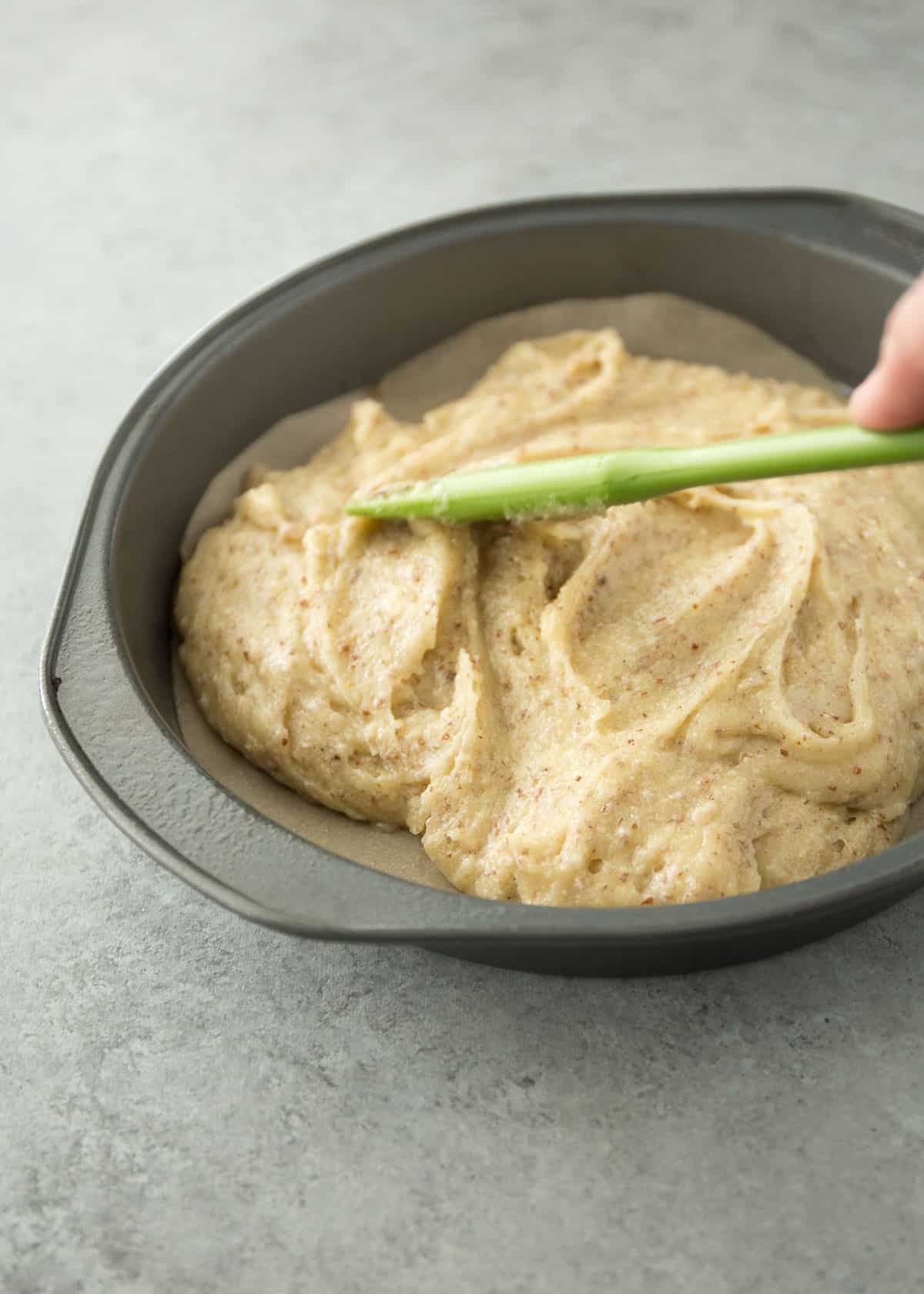 spreading cake batter into a round cake pan