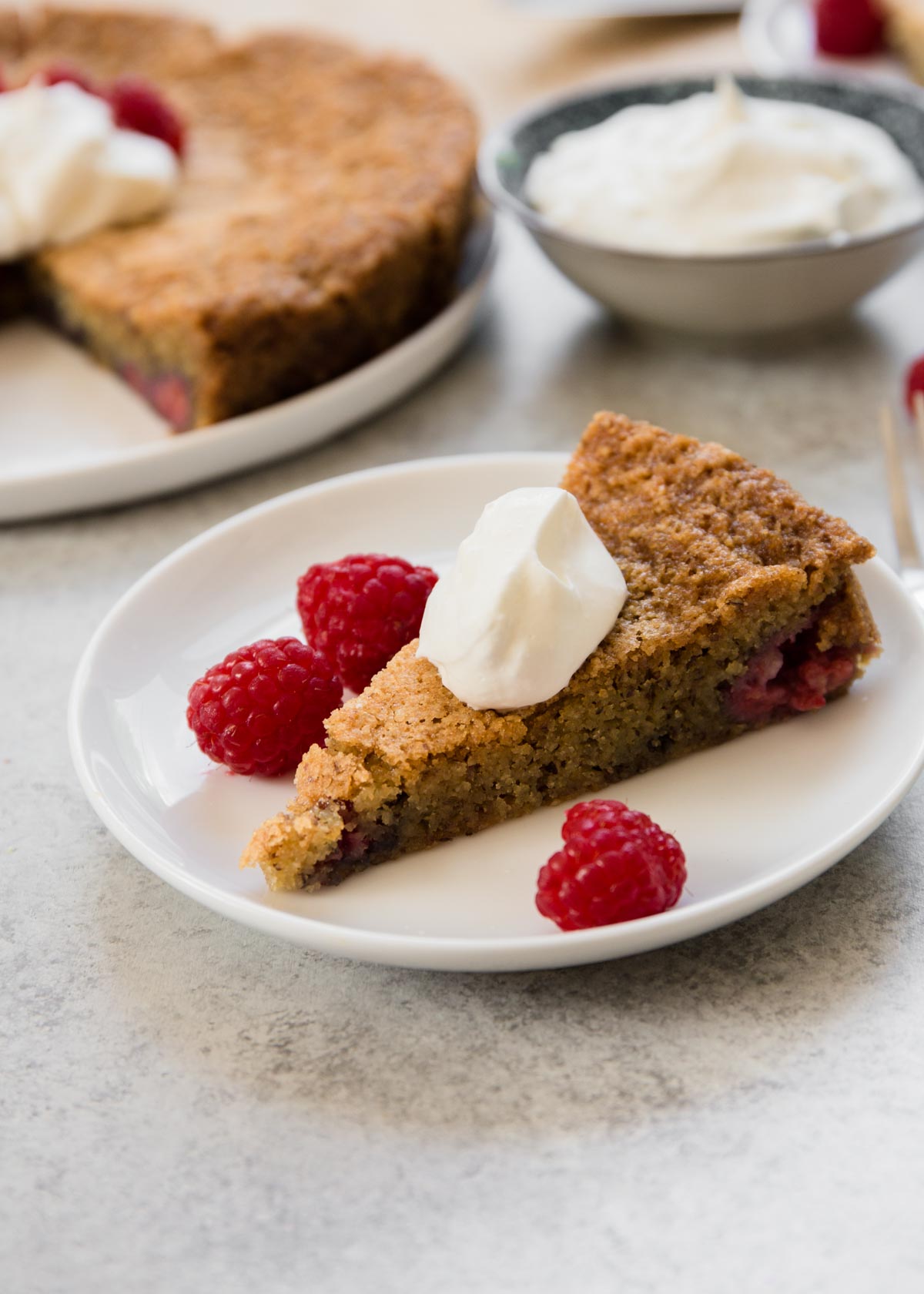slice of raspberry almond snack cake with whipped cream