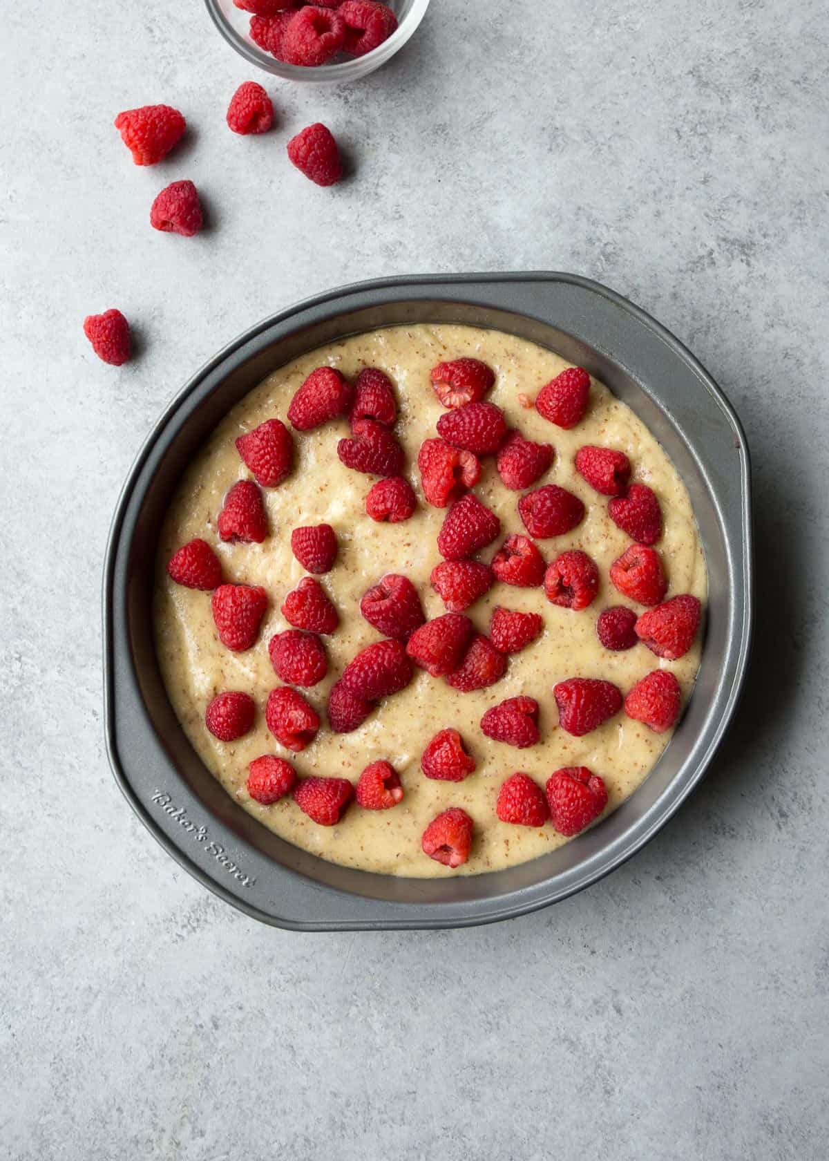 dotting cake batter with fresh raspberries