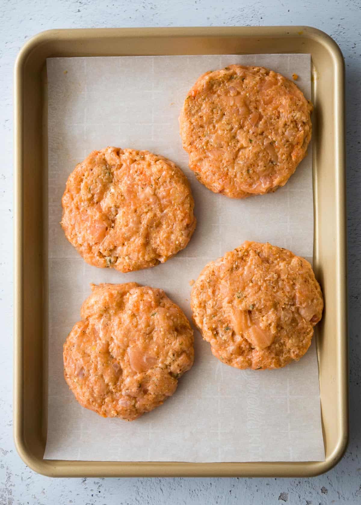 overhead image of uncooked salmon patties on a sheet pan