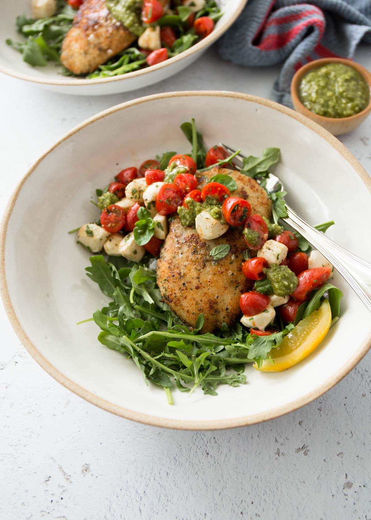 crispy chicken with balsamic tomato salad in a white bowl
