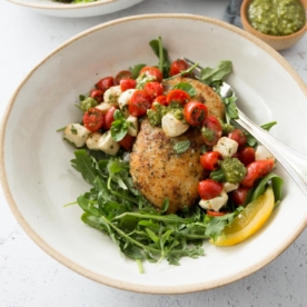 crispy chicken with balsamic tomato salad in a white bowl