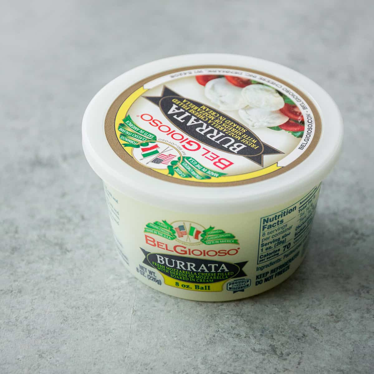 a container of burrata cheese on a grey countertop
