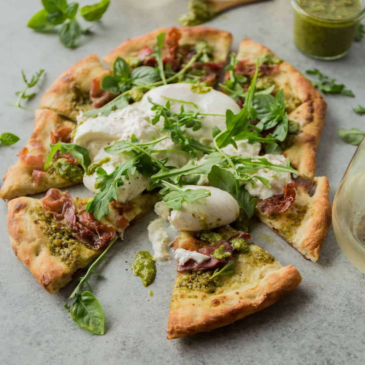 a homemade pizza sliced on a grey countertop