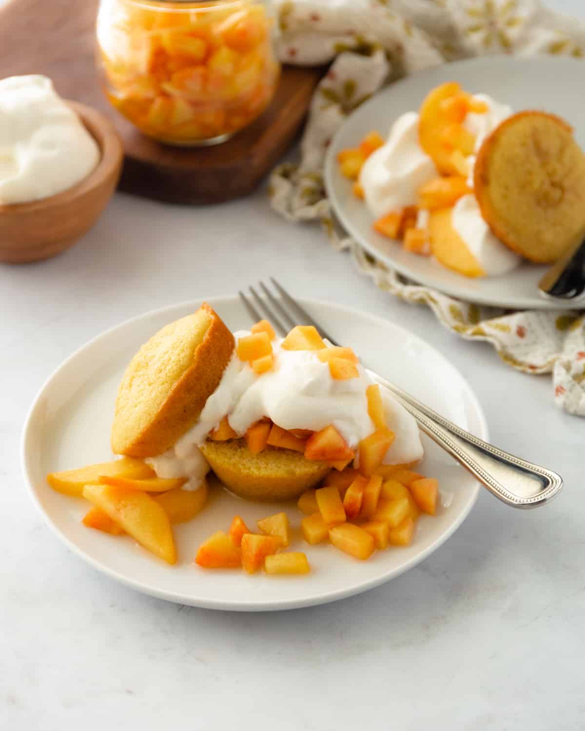 shortcakes and peaches on a white plate