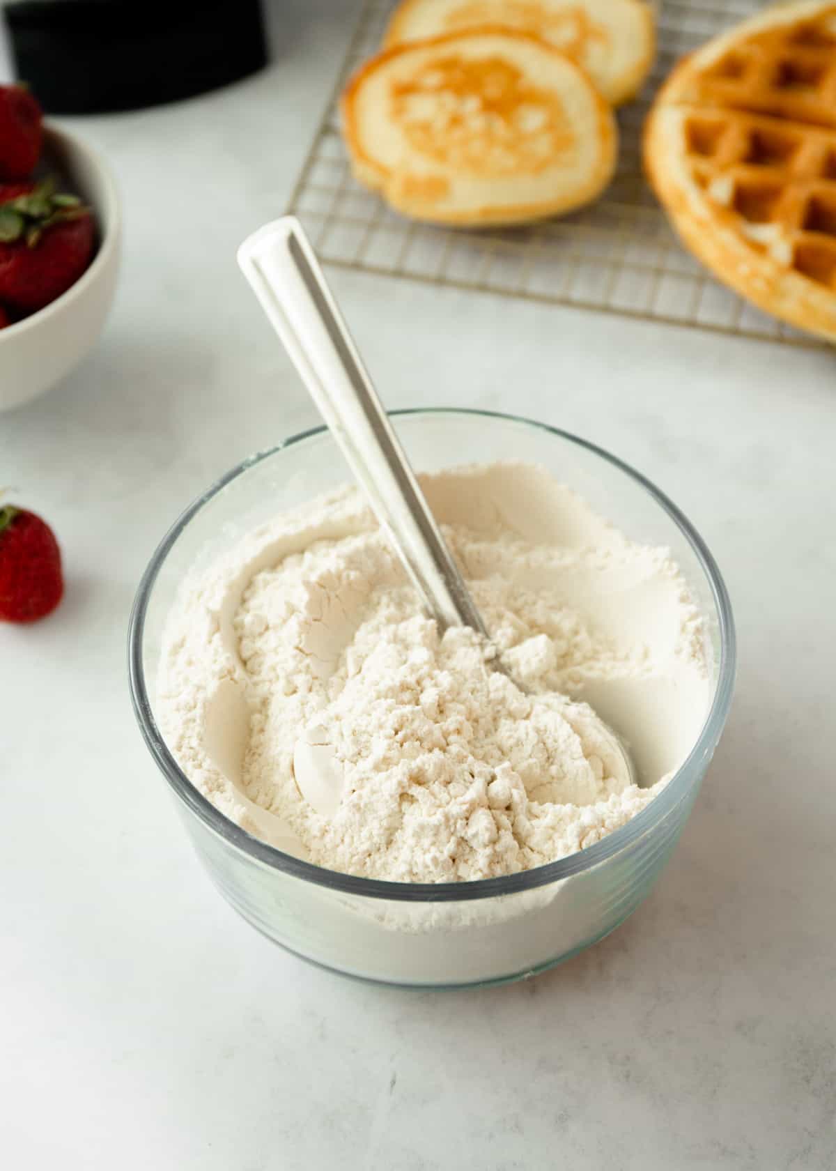 stirring pancake mix in a clear bowl