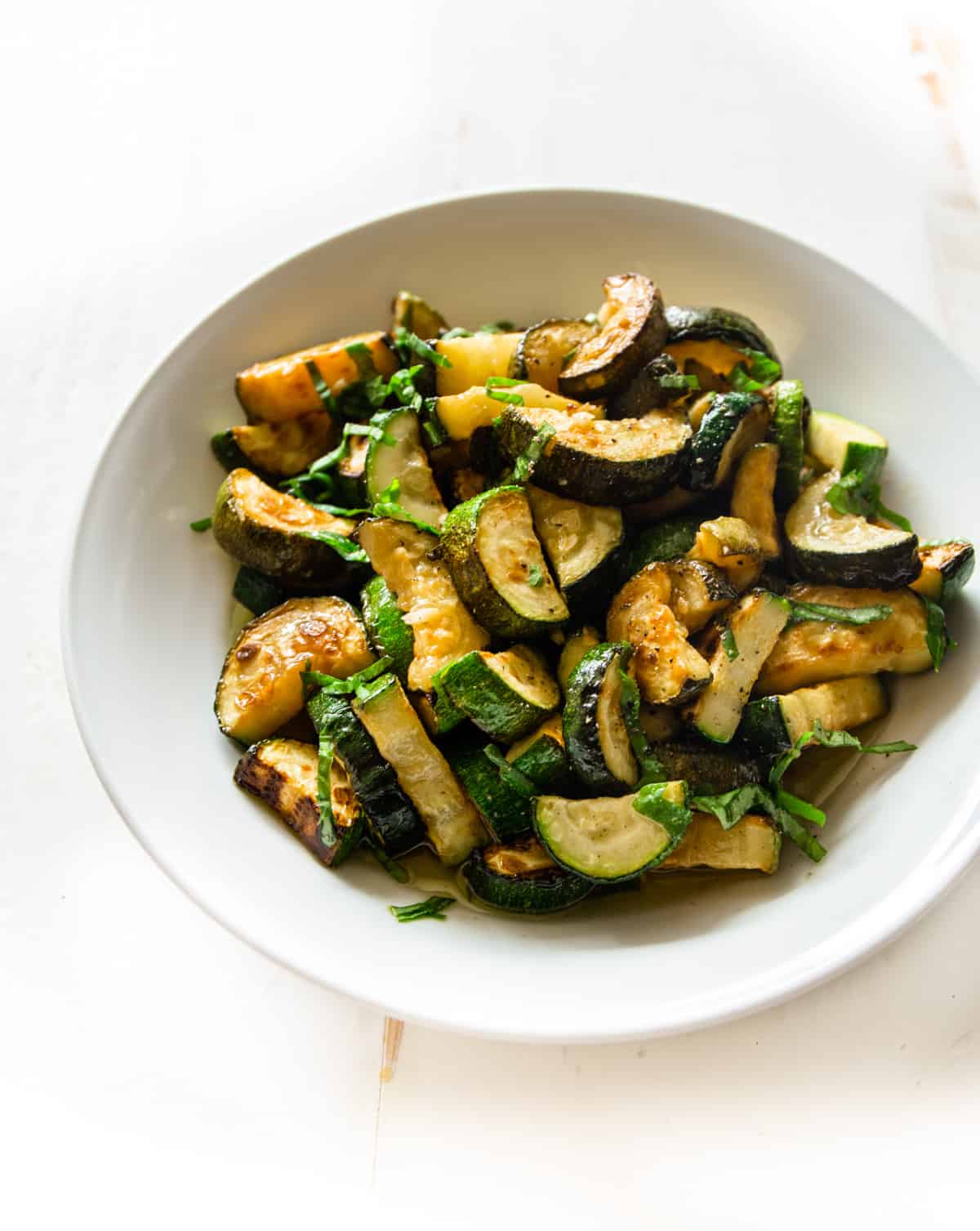 overhead image of cooked zucchini in a white bowl