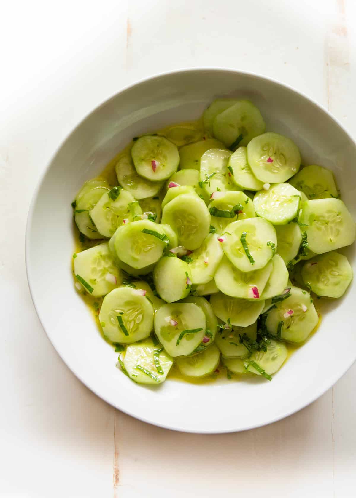 overhead image of cucumbers in a white bowl