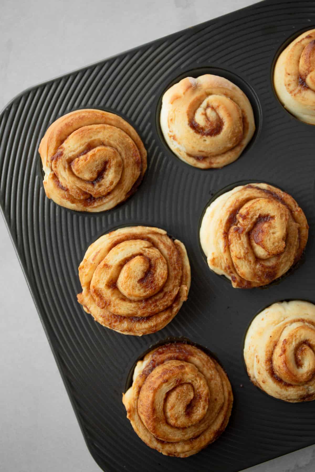 baked cinnamon rolls in a muffin tin