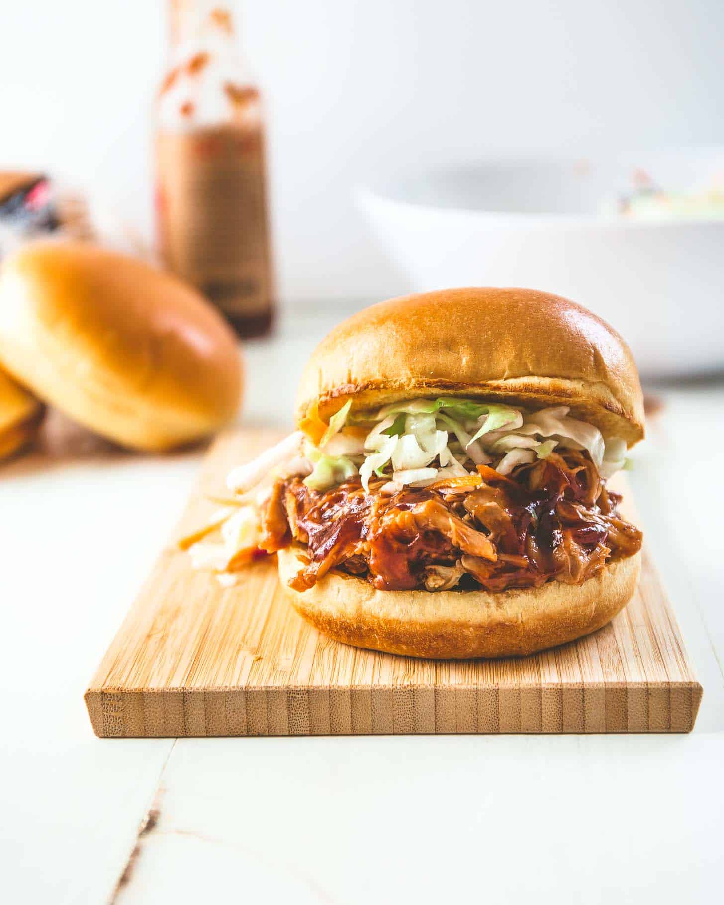  bbq pulled chicken sandwich on a wooden cutting board
